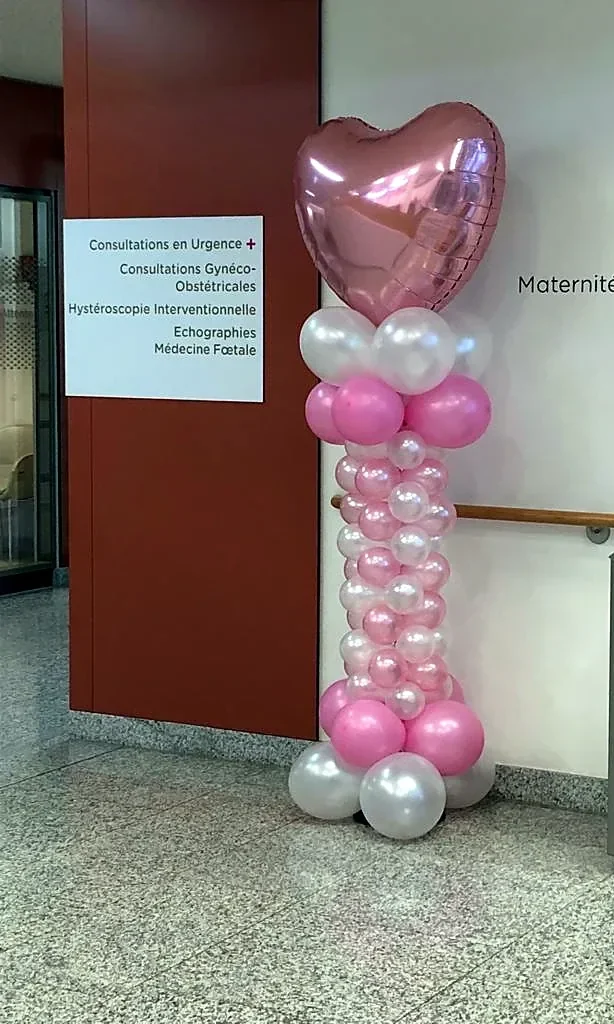Column of pink and white balloons topped with a pink mylar heart, maternity unit reception in Luxembourg